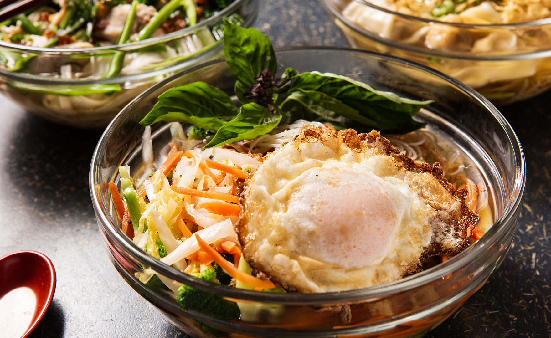 Bowl of noodle soup with vegetables and fried egg
